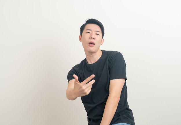 Young Asian man with funny and crazy face on white background