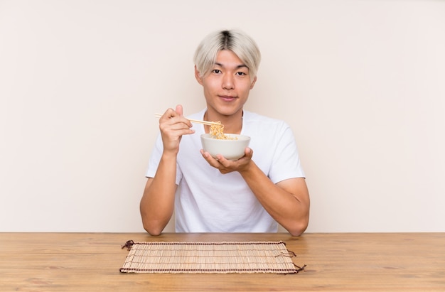 Young asian man with ramen in a table