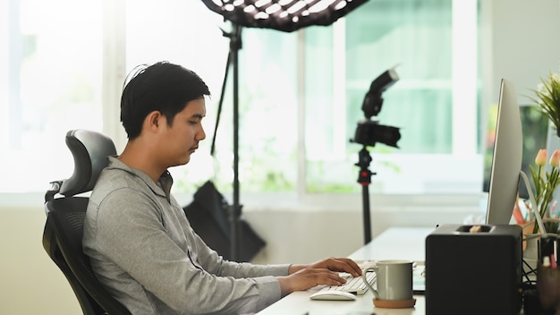 Young Asian man working from home on a computer