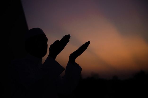 A Young asian muslim man praying on sunsetRamadan festival concept