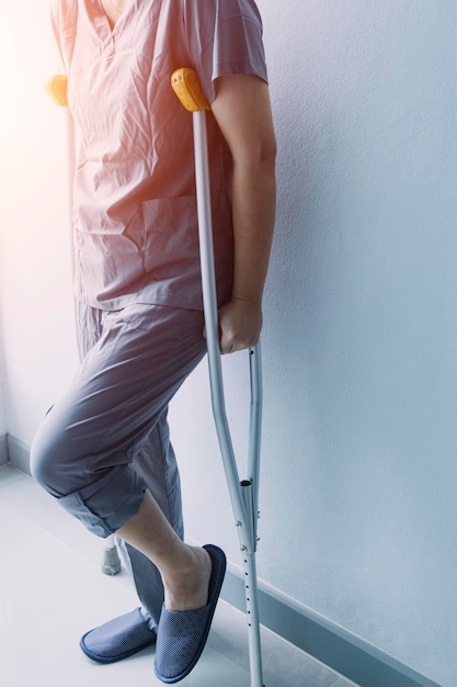 Young asian physical therapist working with senior woman on walking with a walker