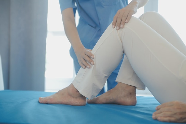 Young asian physical therapist working with senior woman on walking with a walker