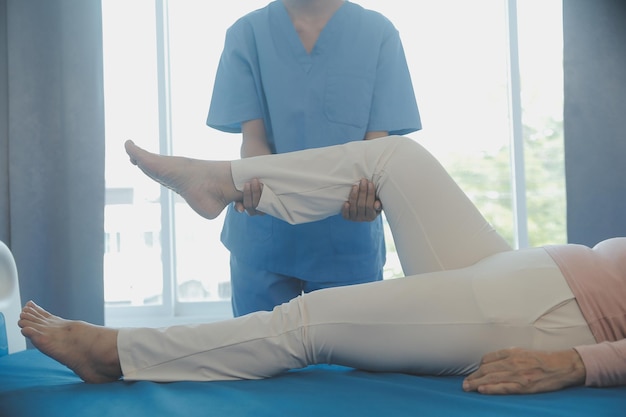 Young asian physical therapist working with senior woman on walking with a walker