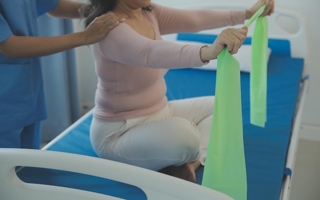 Young asian physical therapist working with senior woman on walking with a walker