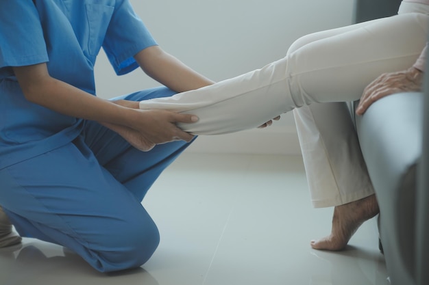 Young asian physical therapist working with senior woman on walking with a walker