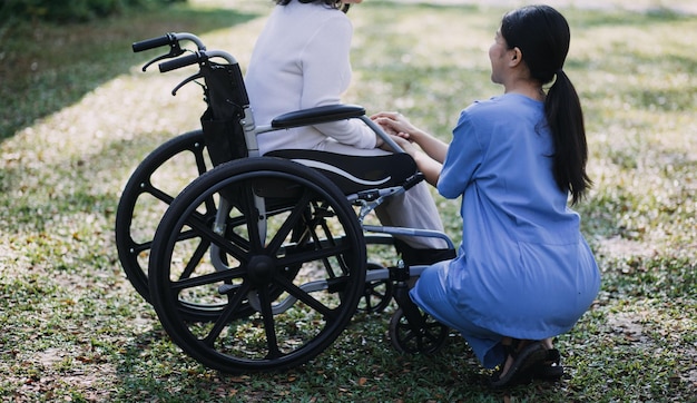 Young asian physical therapist working with senior woman on walking with a walker