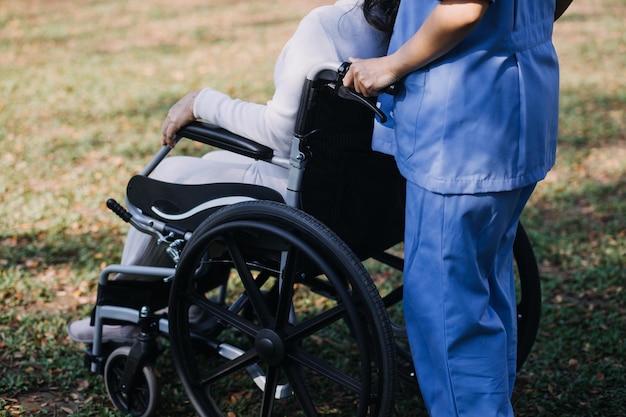 Young asian physical therapist working with senior woman on walking with a walker