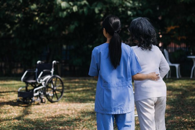 Young asian physical therapist working with senior woman on walking with a walker