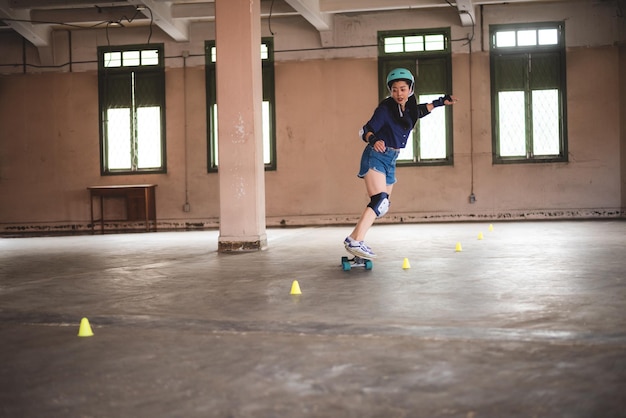 Young Asian teenage girl playing skateboard urban sport happy and fun lifestyle with skateboarding