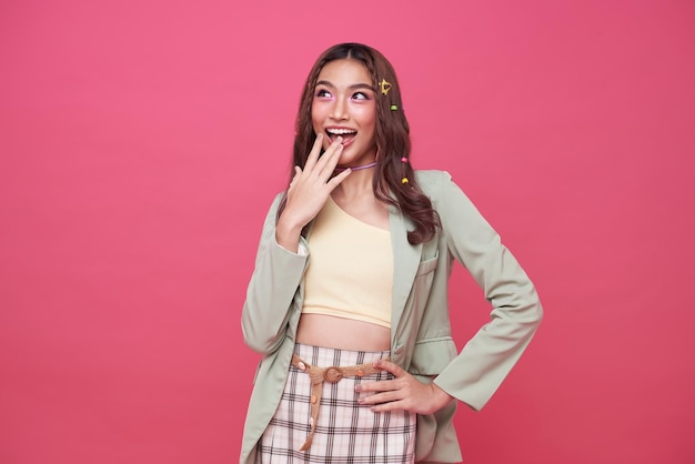 Young Asian teenage girl surprised excited isolated on pink background