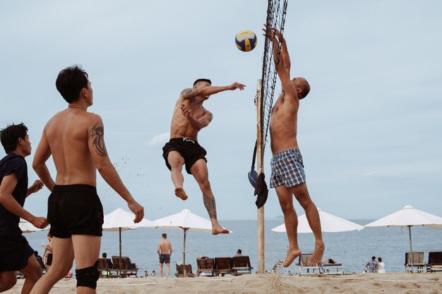 Photo young asian vietnamese play beach volleyball on beach by sea on a summer day nha trang vietnam july 21 2024