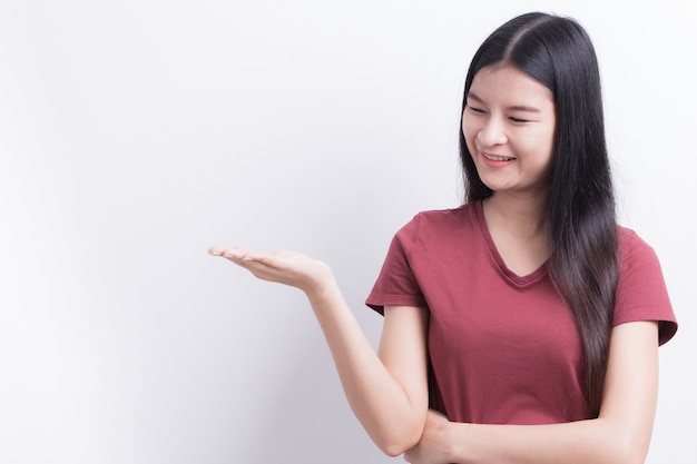 Young asian woman are showing empty hand to put a product or montage.