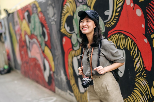 Young Asian woman backpack traveler enjoying street cultural local place and smile Traveler checking out side streets