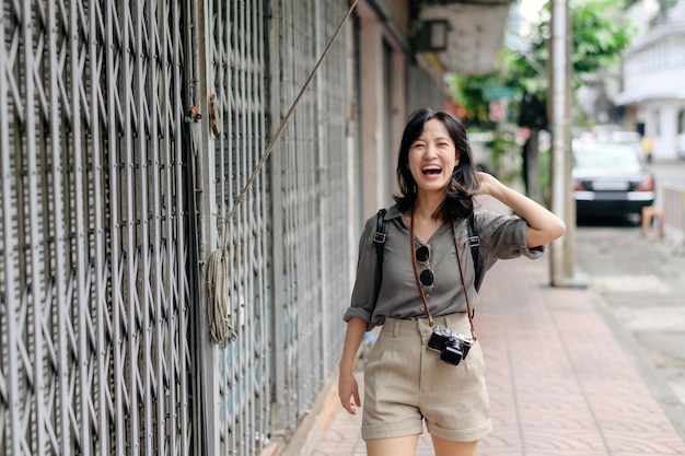 Young Asian woman backpack traveler enjoying street cultural local place and smile Traveler checking out side streets