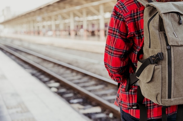 Young Asian woman backpacker traveler walking alone at train station platform with backpack