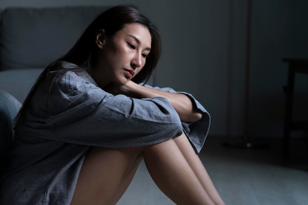 Young Asian woman in bedroom feeling sad tired and worried suffering depression in mental health