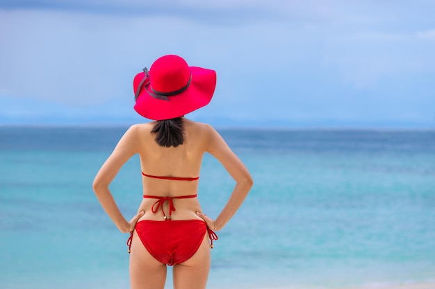 Young asian woman in bikini with hat standing on the beach summer vacation phuket thailand