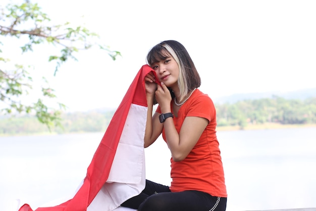 young asian woman carrying indonesian flag