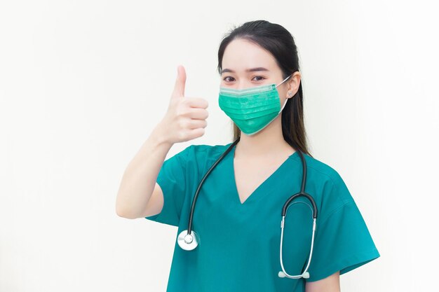 Young Asian woman doctor wearing a medical mask is showing hand as thump up on a white background