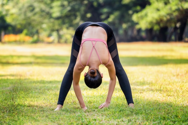 Young Asian woman doing yoga in morning at the park