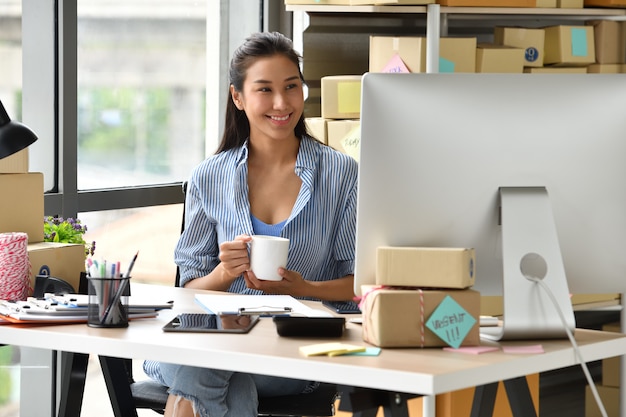 Young Asian woman entrepreneur Business owner working with computer at home