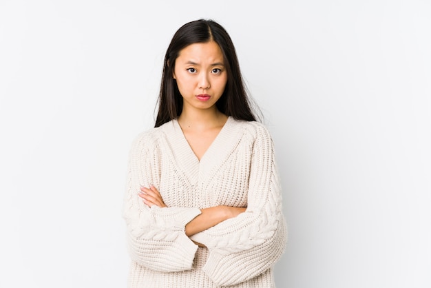 Young asian woman frowning face in displeasure, keeps arms folded