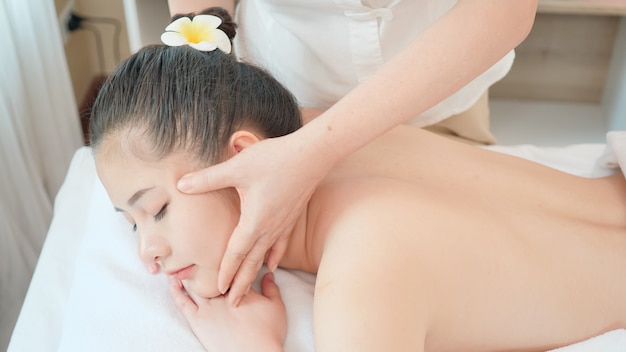 Young Asian woman getting spa massage treatment at beauty spa salon. Face massage, Relaxing massage, Spa skin and body care