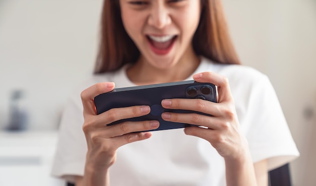 Young Asian woman hand playing games on smartphone, lifestyle leisure in living room at home.