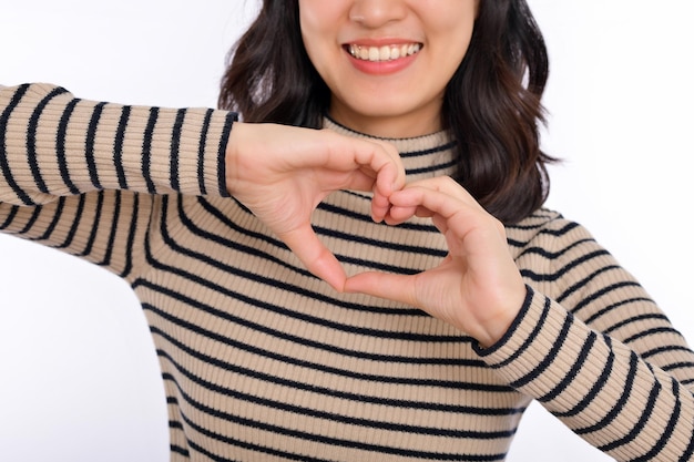 Photo young asian woman hands making a heart shape on a white isolated background