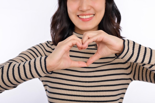 Photo young asian woman hands making a heart shape on a white isolated background