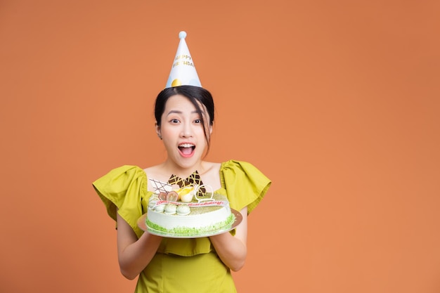 Young Asian woman holding birthday cake