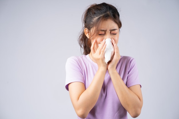 Young Asian woman is wiping her nose with a tissue