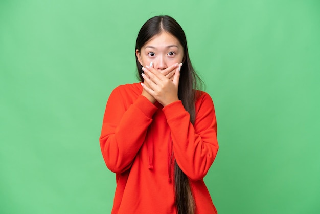 Young Asian woman over isolated background covering eyes by hands and smiling