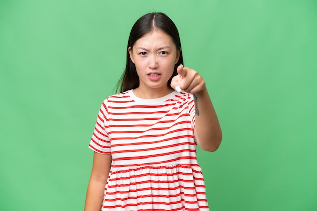 Young Asian woman over isolated background doing surprise gesture while looking to the side