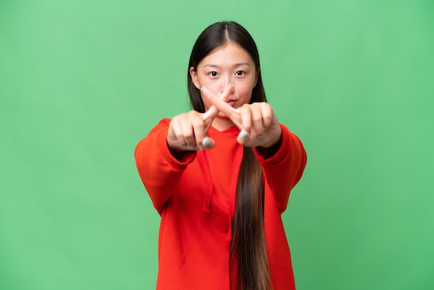 Young Asian woman over isolated background having doubts and with confuse face expression