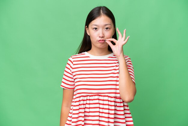 Young Asian woman over isolated background thinking an idea while looking up