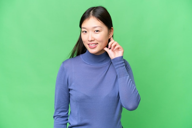 Young Asian woman over isolated chroma key background laughing