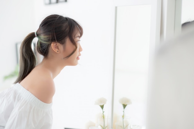 Young asian woman look at mirror