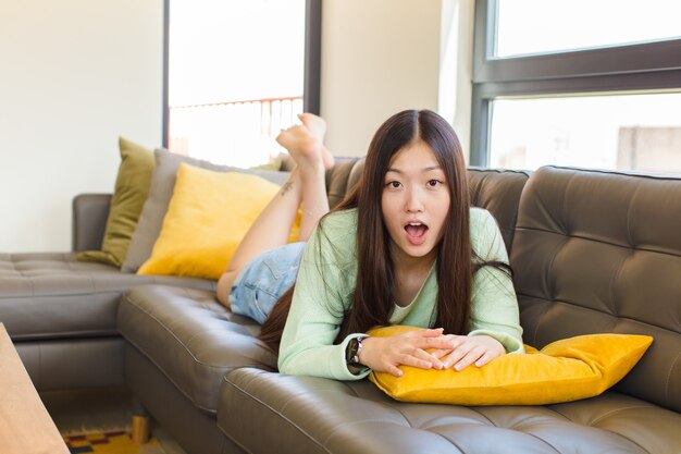 Young asian woman looking shocked, angry, annoyed or disappointed, open mouthed and furious