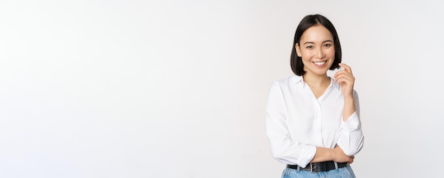 Young asian woman professional entrepreneur standing in office clothing smiling and looking confiden