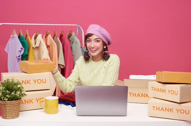 Young asian woman running online store purchase shopping order and box packaging on table