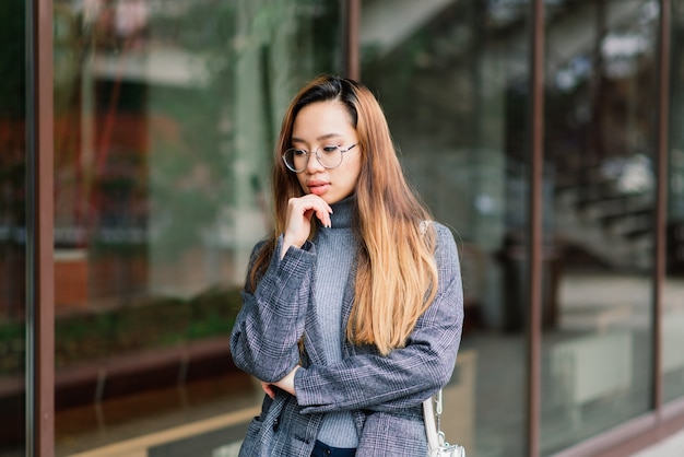 Young Asian woman, sad face portrait in city at the evening