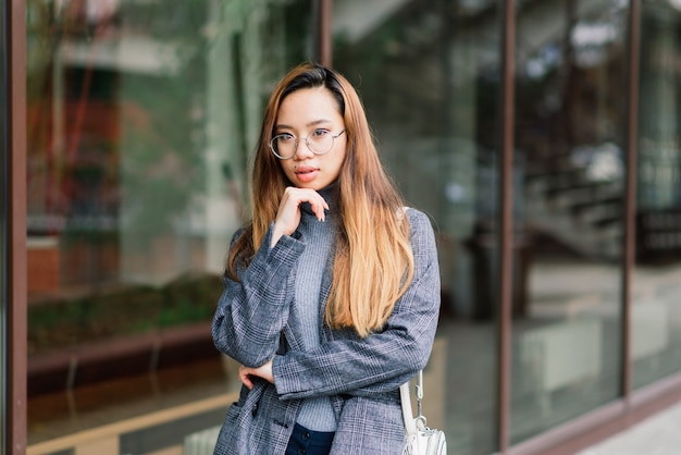 Young Asian woman, sad face portrait in city at the evening