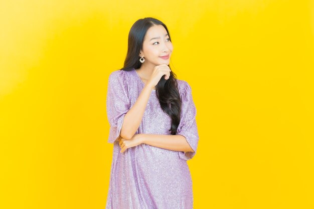 young asian woman smiling on yellow