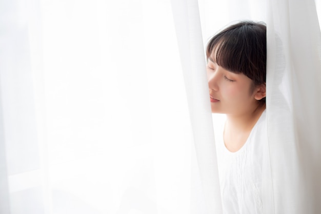 Young Asian woman standing near the window