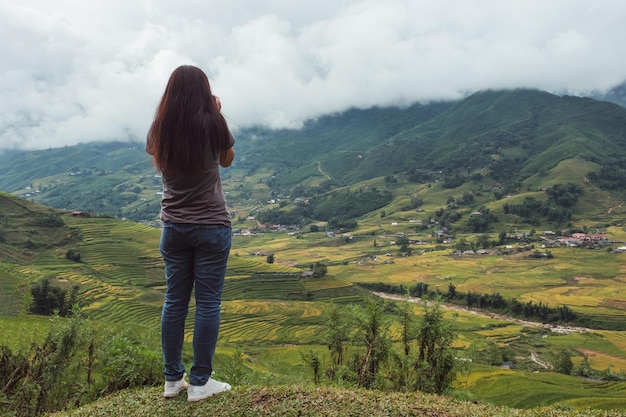 Young asian woman take a photo on top of rice fields