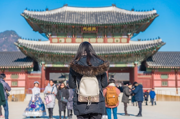 Photo young asian woman traveler with backpack traveling into the gyeongbokgung palace 