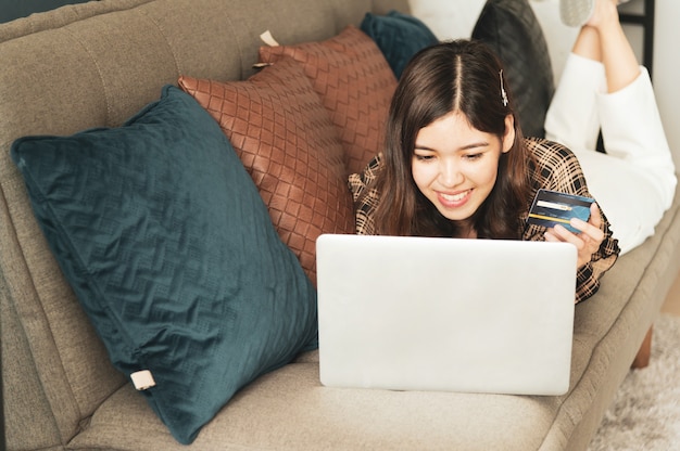 Young Asian woman using credit card for online shopping