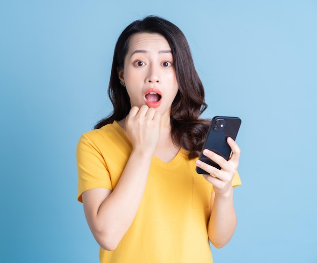 Young Asian woman using smartphone on background