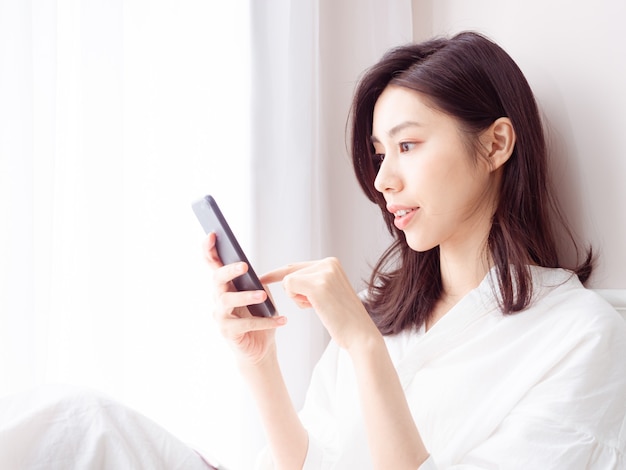 Young asian woman using smartphone at home